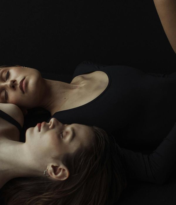 Woman in a calm yoga pose in a softly lit studio.